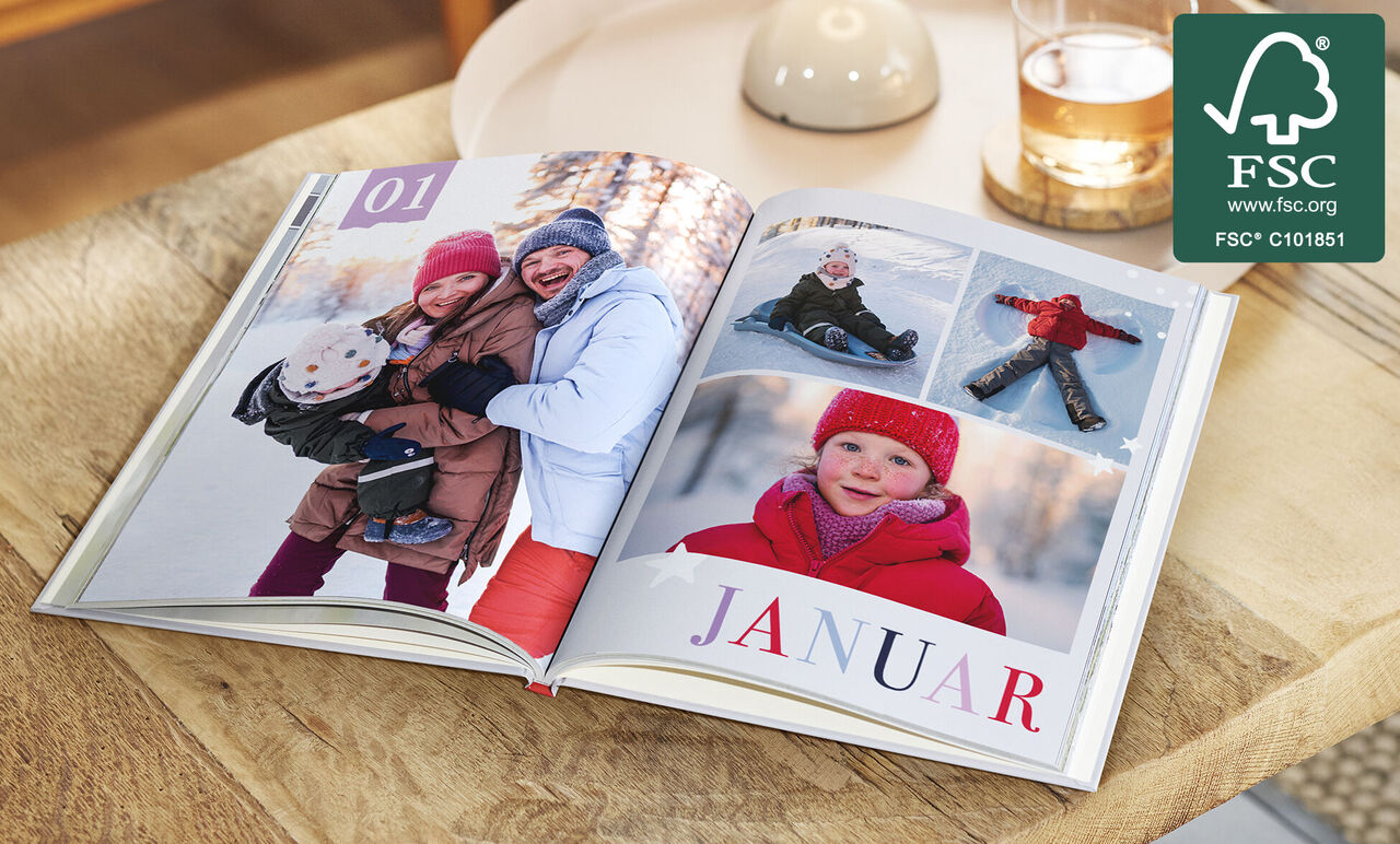 Offenes CEWE FOTOBUCH zeigt fröhliche Winterbilder zum Monat Januar